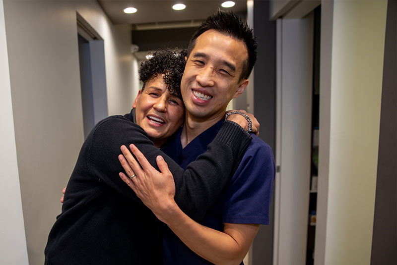 Dr. Chang hugging dental patient
